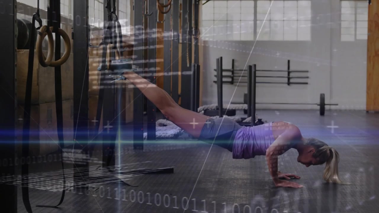 Vertical video: Lady doing decline pushups, ankle straps on rig in gym, purple top grey shorts