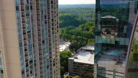 Slowly-dropping-drone-shot-of-skyscrapers-revealing-a-swimming-pool-and-tennis-court-behind-the-Paramount-in-Buckhead,-Atlanta,-Georgia