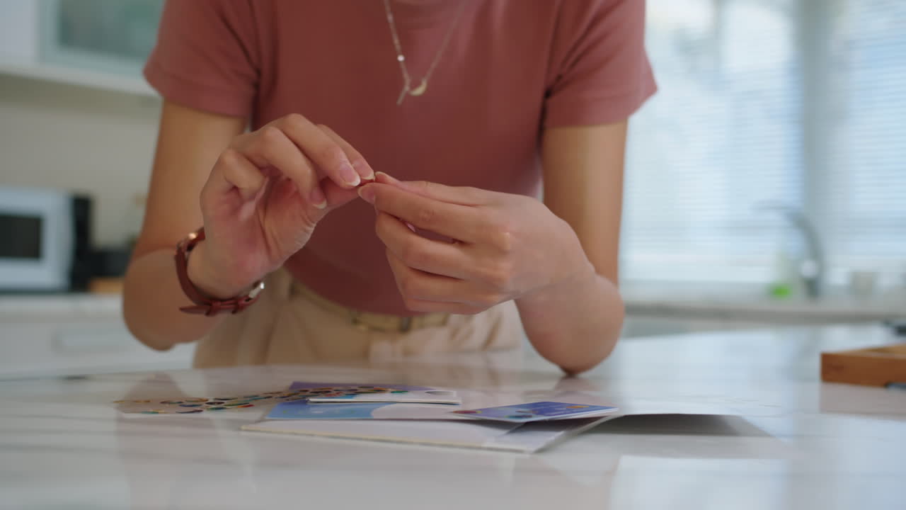 Woman Making Credit Card Decoration with Stickers