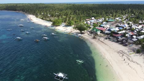 a mesmerizing aerial view of daku island, where a lively coastal community meets unspoiled tropical beauty. surrounded by turquoise waters and swaying palms, it's a true island paradise in siargao