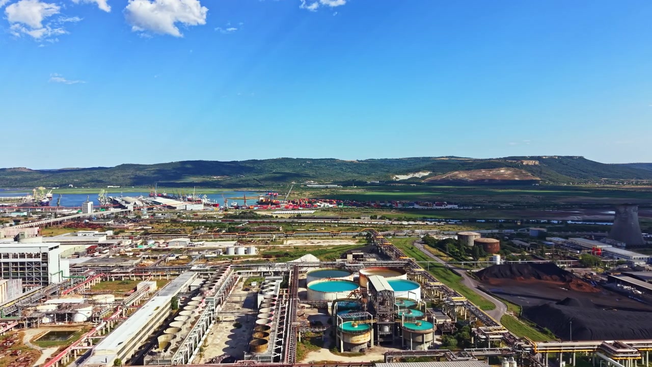 Industriområde med bygninger, maskineri og havn langs flodbredden i dagtimerne