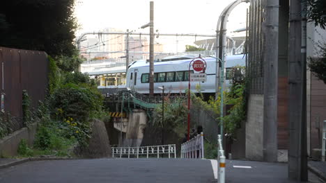 subway train running across the railway with skylines at background in tokyo, japan