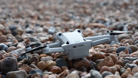 un dron gris yace sobre los guijarros de una playa, brighton, sussex, inglaterra