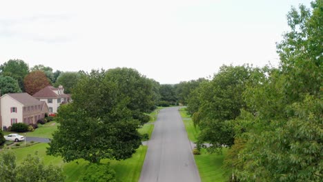 Rising-aerial-from-street-reveals-large-upscale-homes-and-houses,-mansion-in-USA