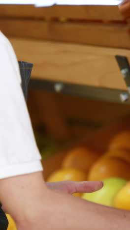 una trabajadora sonriente guardando manzanas.