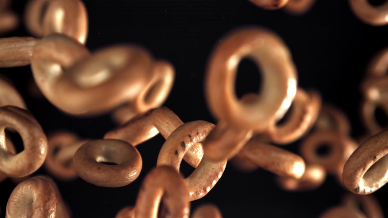 Golden Brown Ring-Shaped Baked Goods Falling in Slow Motion