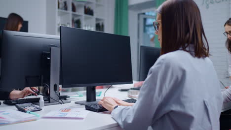 una mujer trabajando en una computadora en una oficina