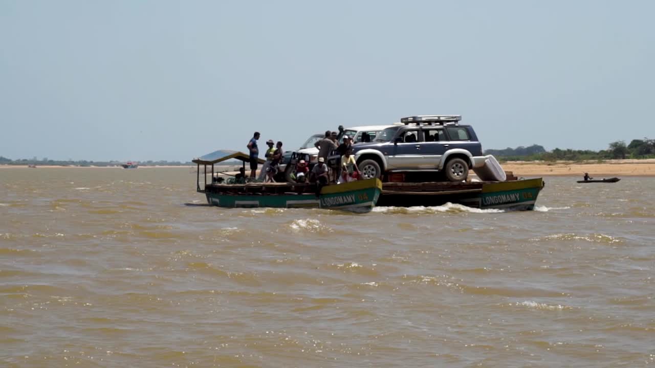 River ferry transports cars across Tsiribihina river in Madagascar. Wide shot of ferry.