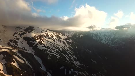 Aerial-view-of-austrian-mountains-snowy-peaks-touching-the-clouds