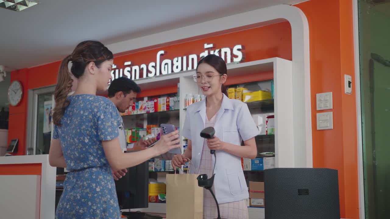 女性の薬剤師がコンタクトレス支払いのためのスマートフォンでバーコードをスキャンしています