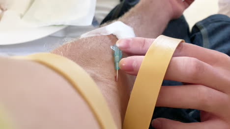 close up of an intravenous cannula needle being removed from a patient