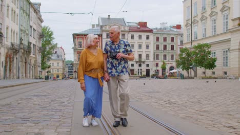 senior old stylish tourists man, woman, grandmother, grandfather family having a walk in summer city