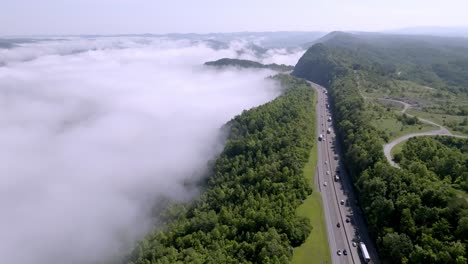 clouds and fog along with traffic on interstate 75 near jellico, tennessee in the cumberland mountains with drone video stable wide shot