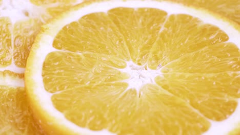 Close-up-fresh-valencia-orange-sliced-with-white-background-shallow-focus-and-slowly-rotating