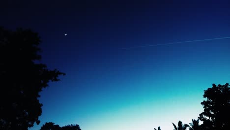 contrail against beautiful night sky with moon