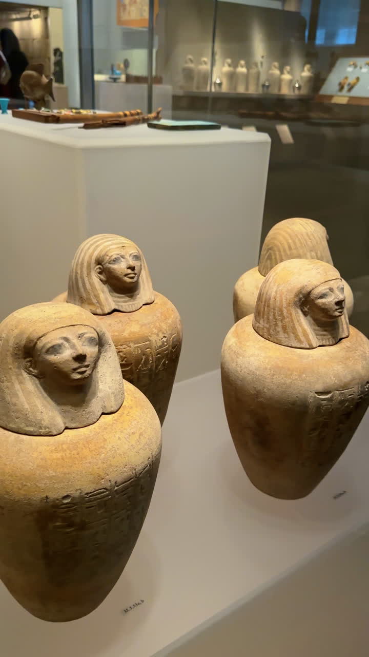 Nova Iorque, EUA, 2 de março de 2026: Vasos canopos de cerâmica do Antigo Egito com tampas de cabeça esculpidas. Close-up de vasos funerários de cerâmica com tampas humanas em exposição em uma mostra de museu na cidade de Nova Iorque.