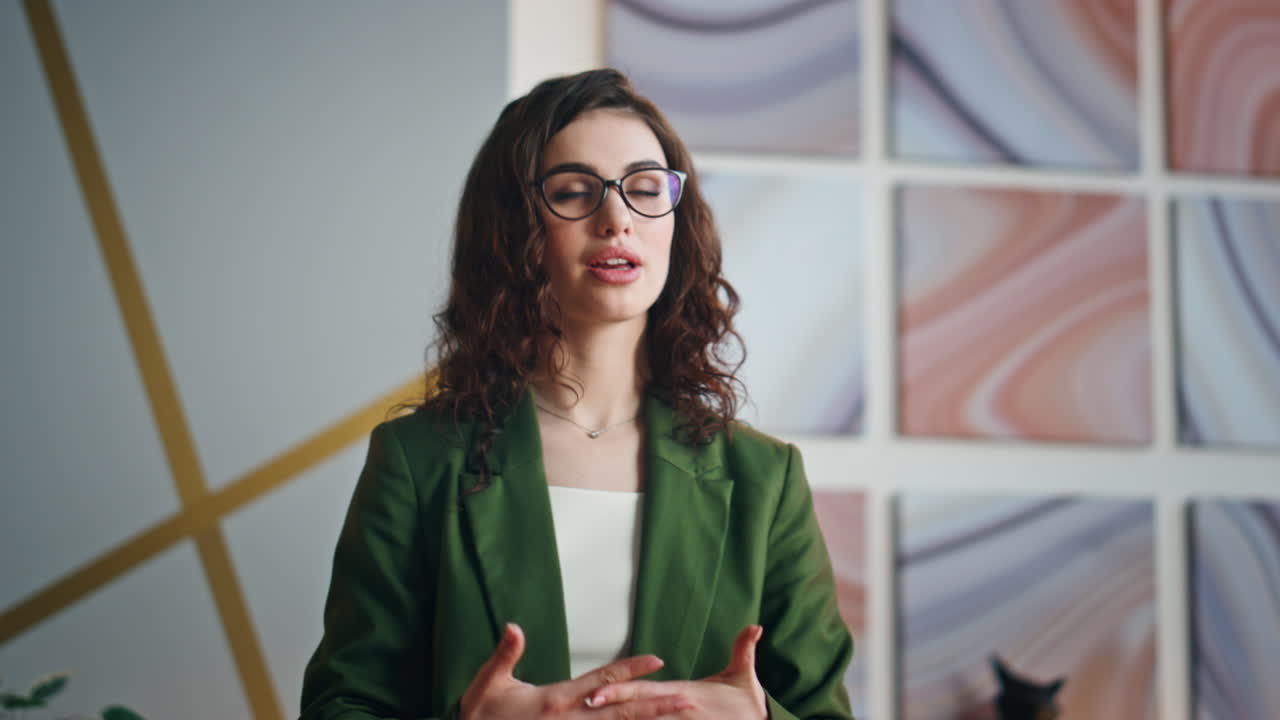una chica hablando de cerca en una oficina. una mujer hablando en un seminario en línea.