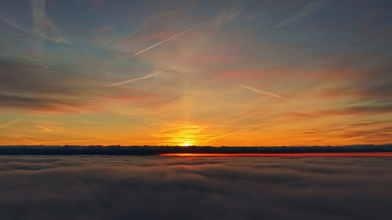 Stunning aerial sunset view over clouds with vibrant colors and peaceful vibe