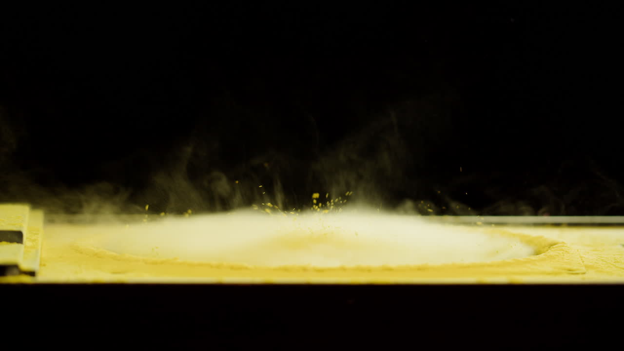 Polvere gialla che danza e reagisce alle onde sonore.