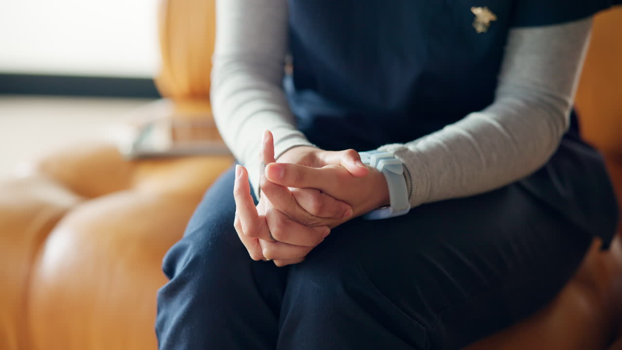 Eftertænksom læge sidder med foldede hænder