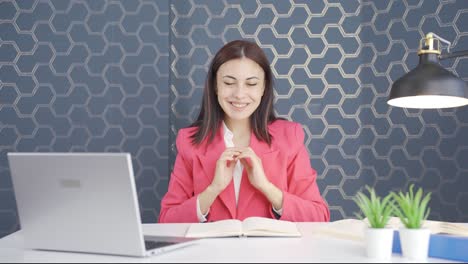joven mujer de negocios haciendo el corazón a la cámara.