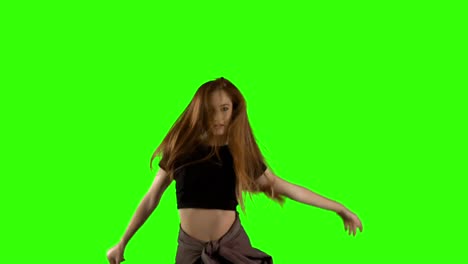 young woman dancing against green screen background