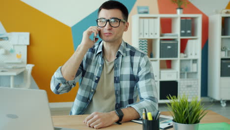 hombre hablando por teléfono en una oficina moderna