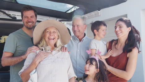 Retrato-De-Una-Familia-De-Varias-Generaciones-Cargando-Equipaje-En-La-Parte-Trasera-Del-Automóvil-Mientras-Se-Van-De-Vacaciones-De-Verano