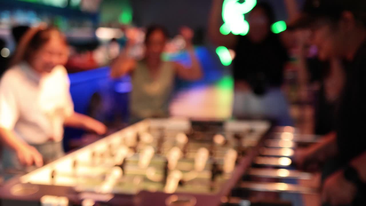 Friends enjoying a lively foosball match