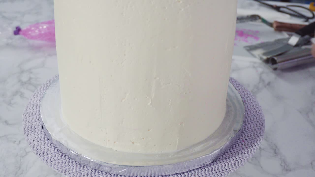 Frosting round funfetti cake with white italian buttercream frosting.