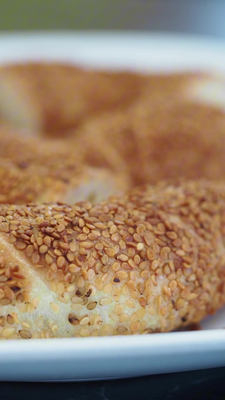 Primo piano di pane turco Simit appena sfornato su un piatto bianco