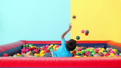 Lindo-Niño-Sumergiéndose-En-La-Piscina-De-Bolas