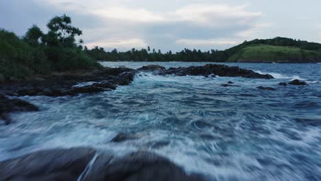 Rocky-coast-at-Hummanaya-Bay-with-turbulent-waves-on-water-surface,-aerial