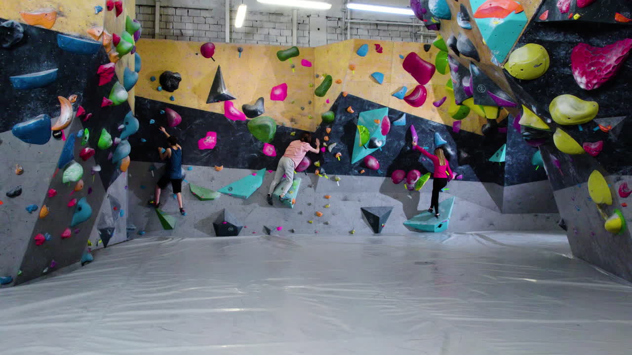 adolescentes haciendo bouldering en un gimnasio