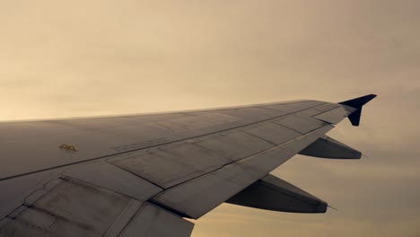 Pov-:-Flügel-Eines-Flugzeugs,-Das-Bei-Sonnenaufgang-Durch-Die-Wolken-Fliegt