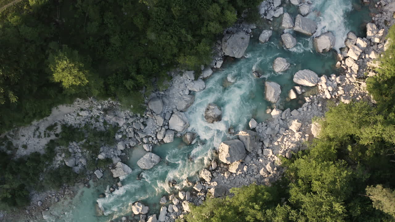 Aerial View of a Turquoise River Winding Through a Mountain Forest