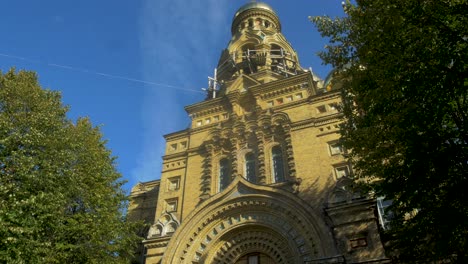 view of orthodox st nicholas naval cathedral golden domes and crosses on blue sky in sunny autumn day at karosta, liepaja, tilt up wide shot