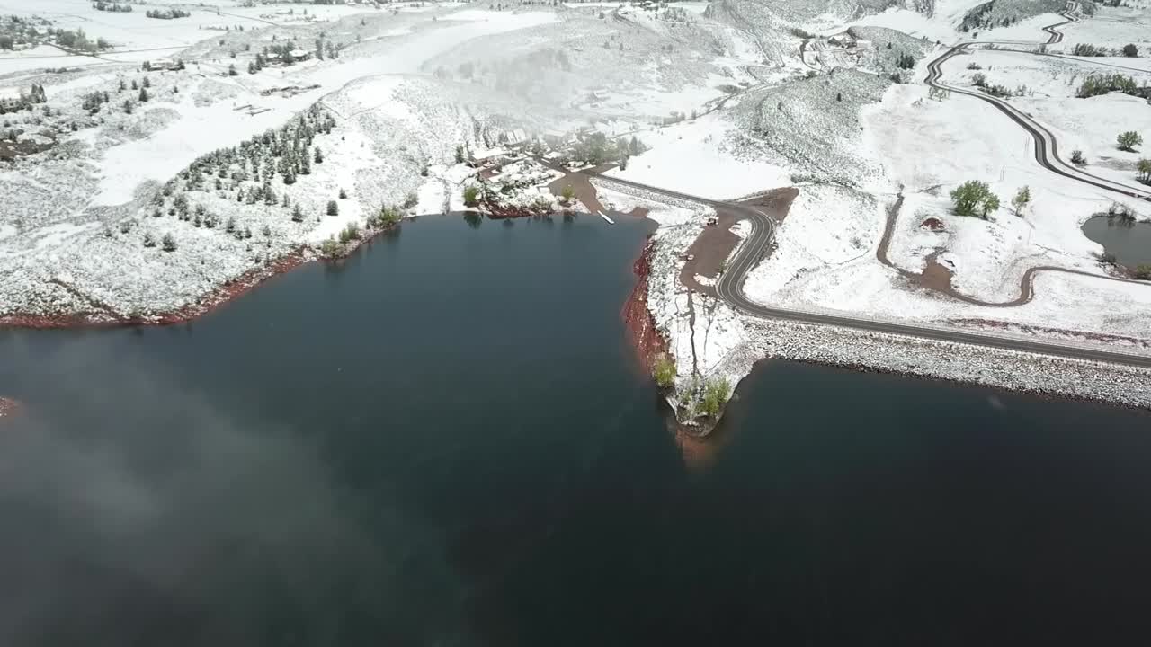 Aerial flight over large lake and snow during winter