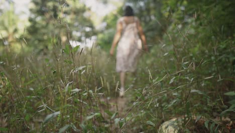 close-up shot of young woman walks in a lush forest, with mixed focus and blur effects, creating a dreamy atmosphere