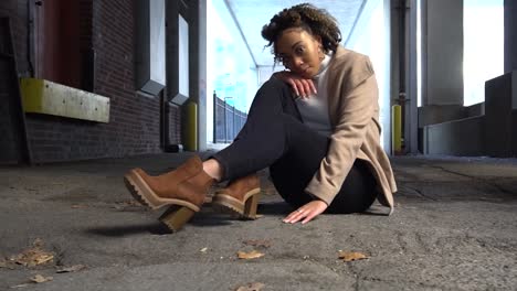 Black-model-poses-for-a-photographer-in-an-alley-during-a-photoshoot