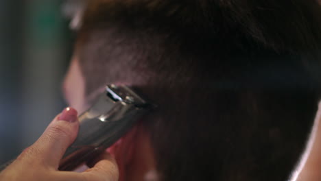 Hairdresser-tools.-Close-up-of-male-hands-brushing-electric-hair-clippers.-Hairdressers-prepare-hair-machine-for-next-client.-Man-clean-black-shaving-machine