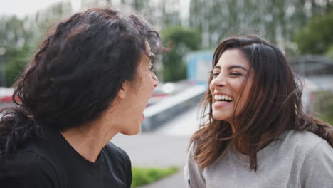 dos amigas se reúnen en un parque de patinaje urbano.