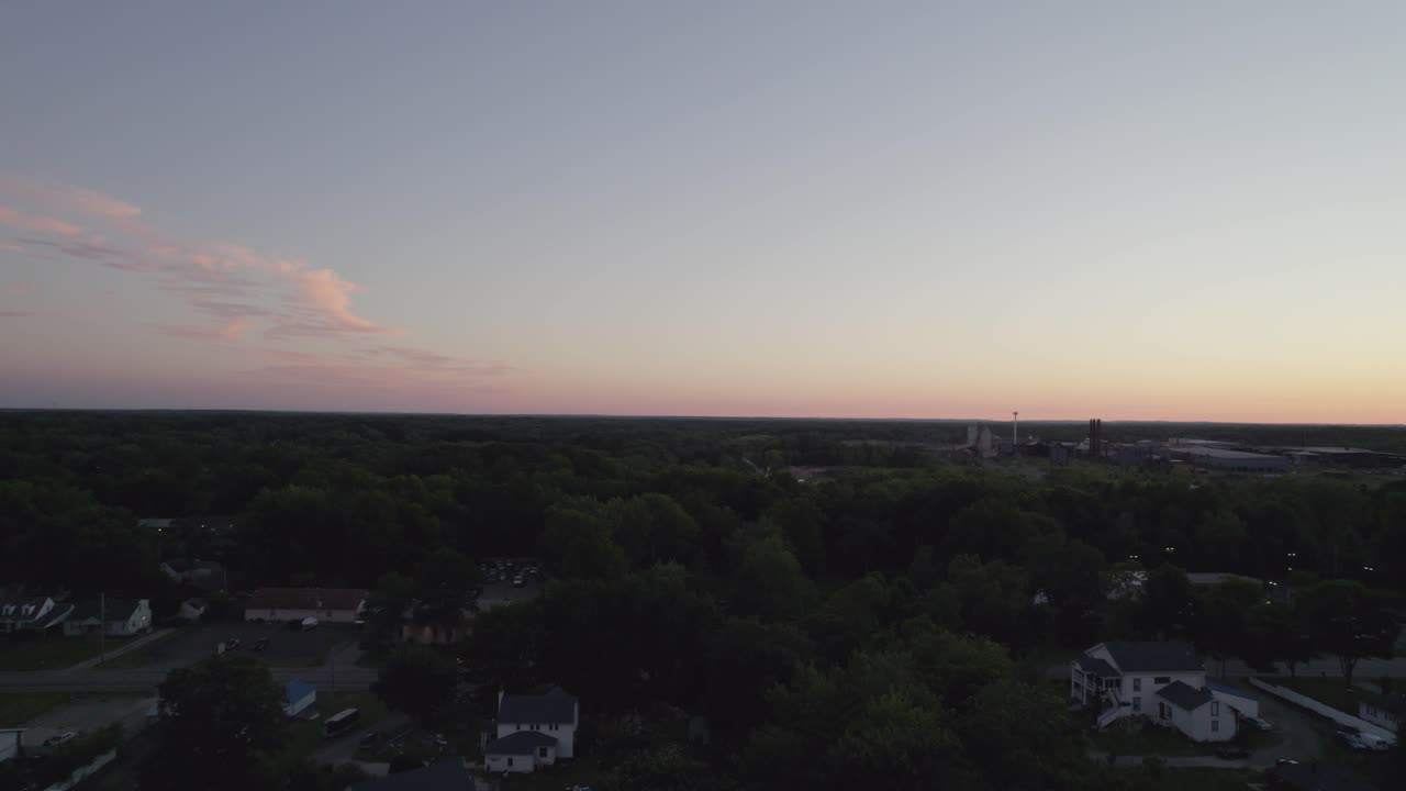 Frontal tracking during dusk with drone in a small town near the forest