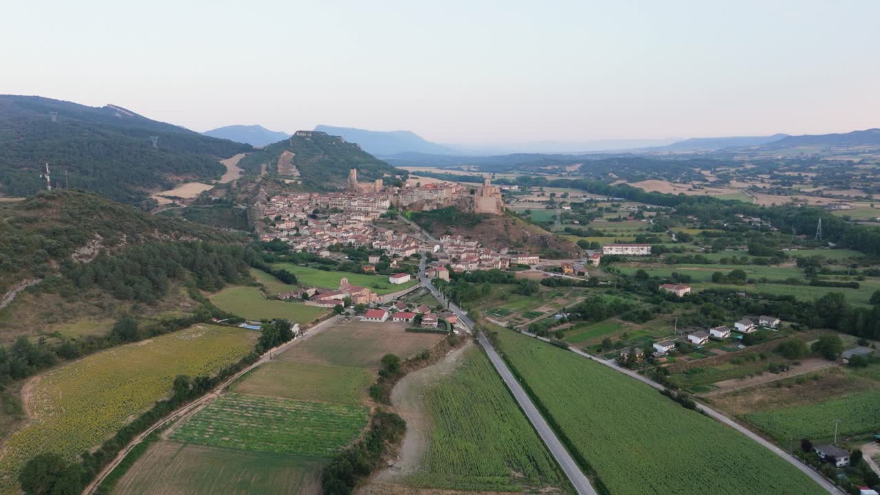 Approaching drone shot of an agricultural village by a mountainside in Valderama, a Spanish town in Castille and Leon, Spain.