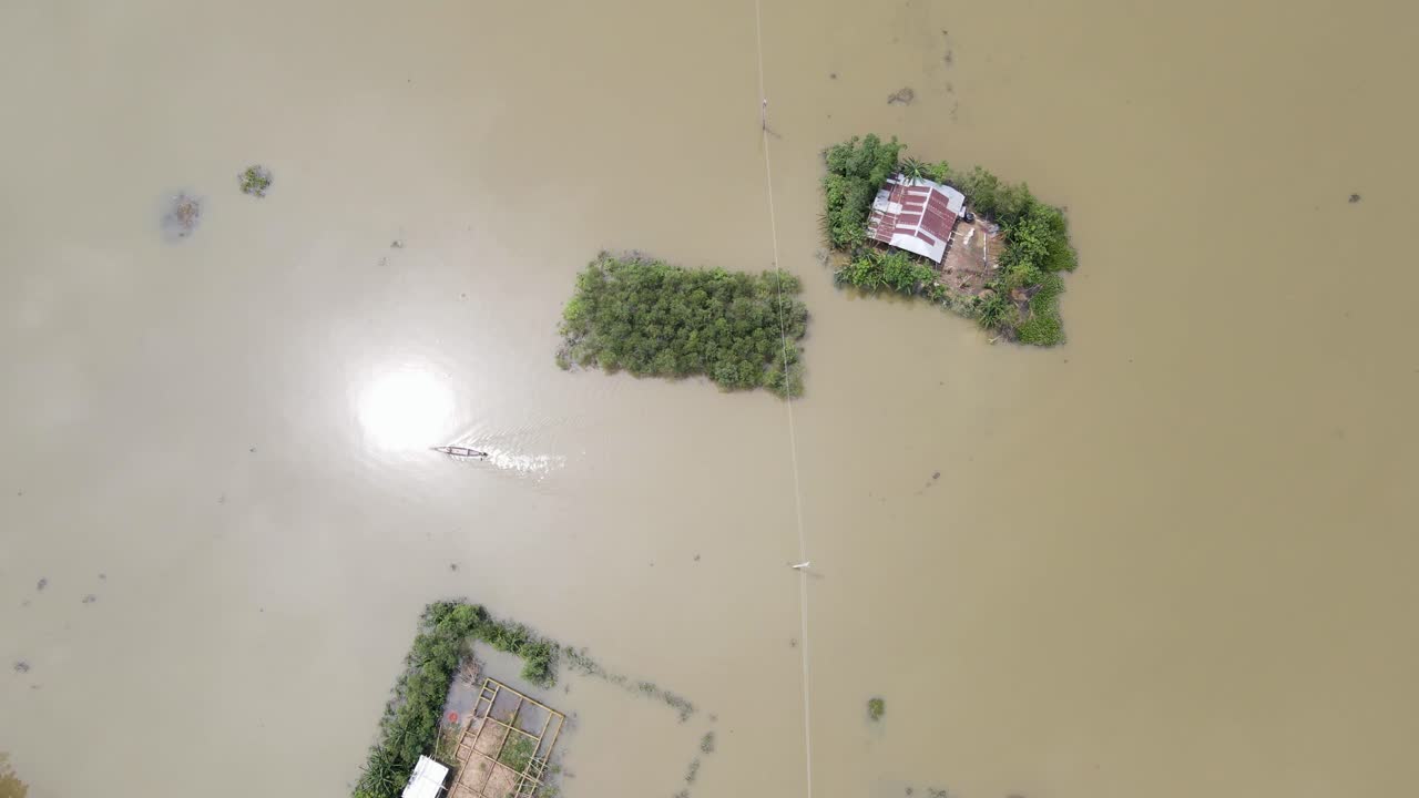ภาพมุมสูงของภูมิประเทศที่ถูกน้ำท่วมซึ่งมีบ้านเรือนและเรือ