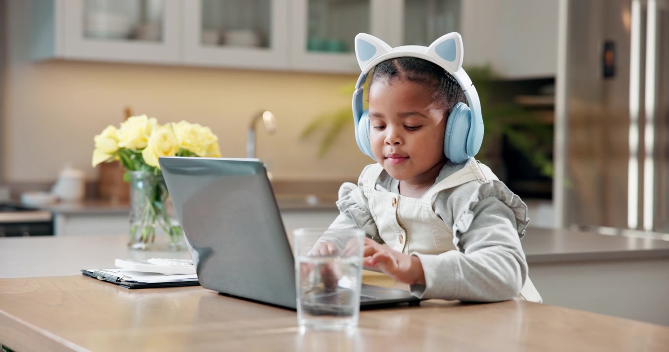 Young Girl Wearing Cat Ear Headphones Using Laptop at Home