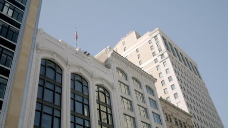 buildings, vehicles and pedestrians in downtown detroit, michigan with video moving down in slow motion.