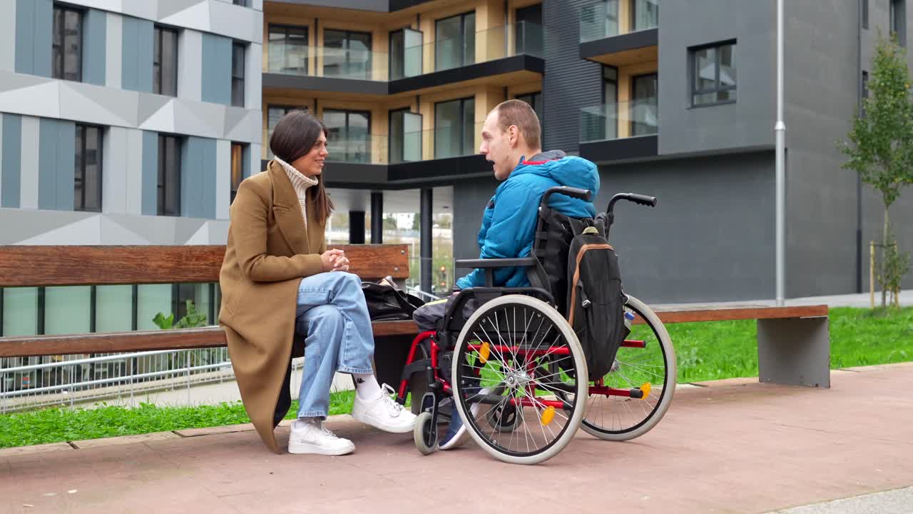 Conversazione tra una donna e un uomo in sedia a rotelle