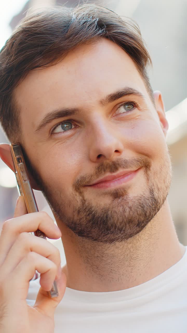 Ritratto di un uomo felice che ha una conversazione remota parlando sullo smartphone buone notizie pettegolezzi in città