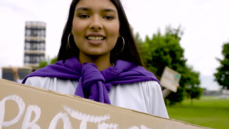 primer plano de una niña sosteniendo un cartel y hablando